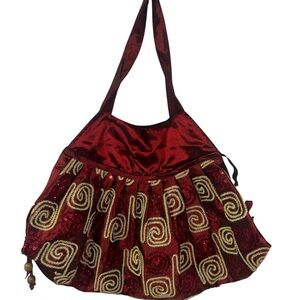 Burgundy hobo handmade sequin shoulder bag with gold embroidered swirl patterns.
